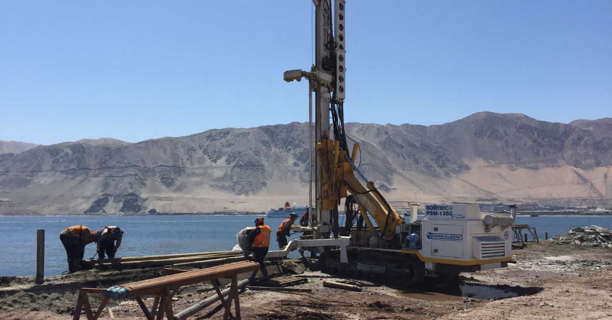 Drilling rig installing micropiles for a pipe umbrella system in coastal geotechnical works.